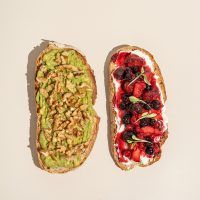 Tostada de aguacate y nueces; y tostada queso crema y frutos rojos